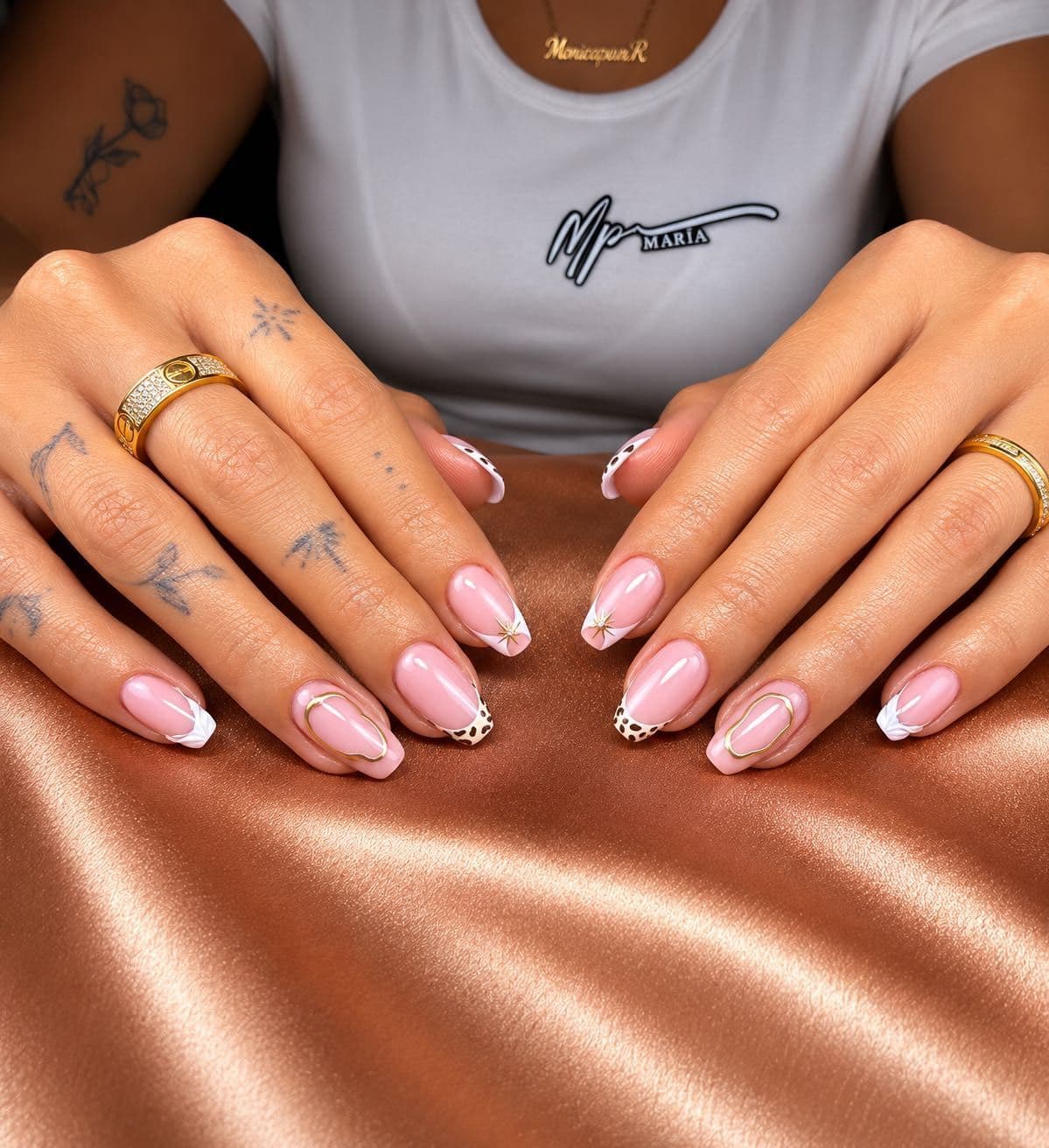 Pink manicure with decorated tips, white petals and gold accents
