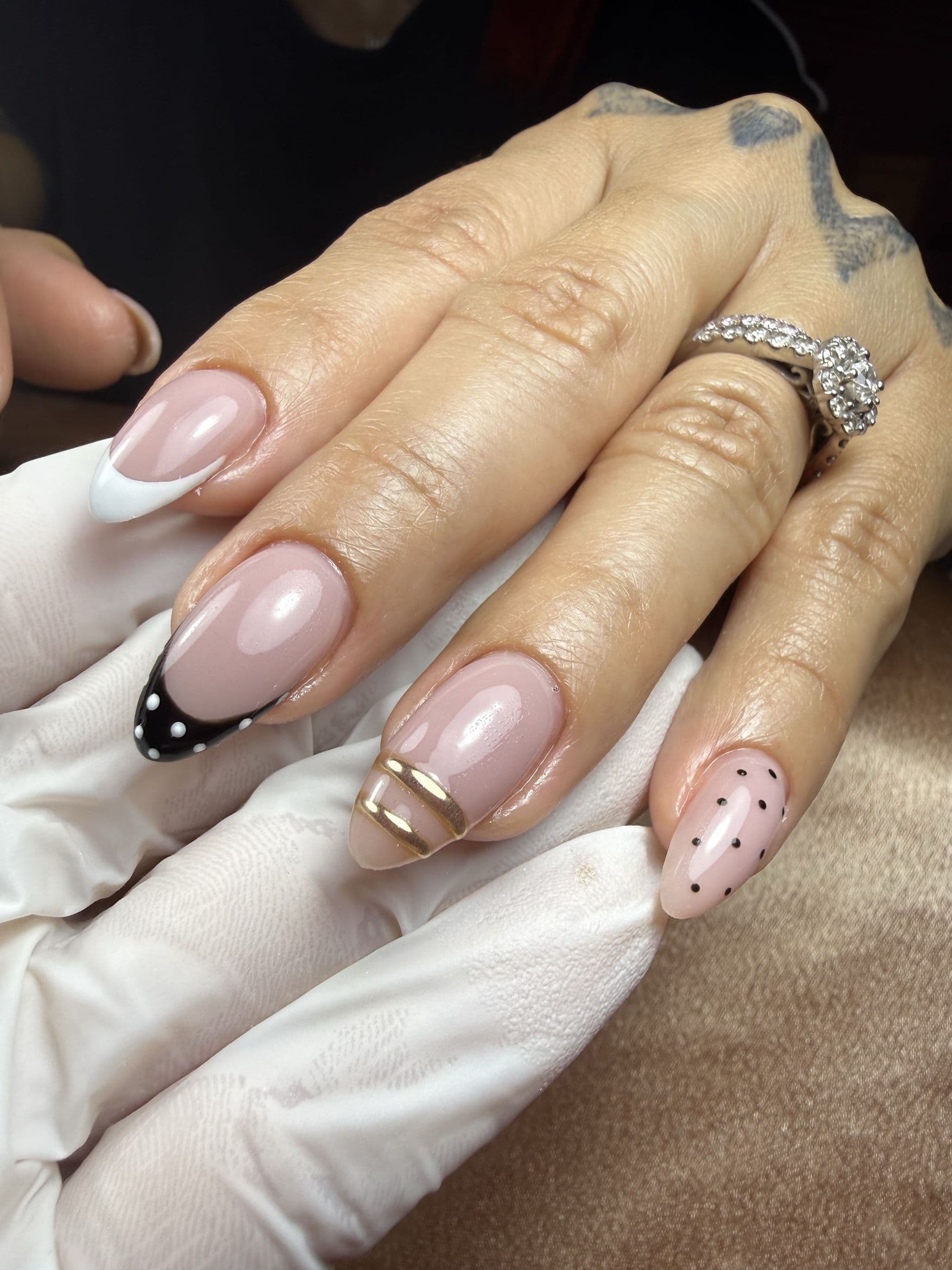 French manicure with black and white tips, polka dots and gold lines