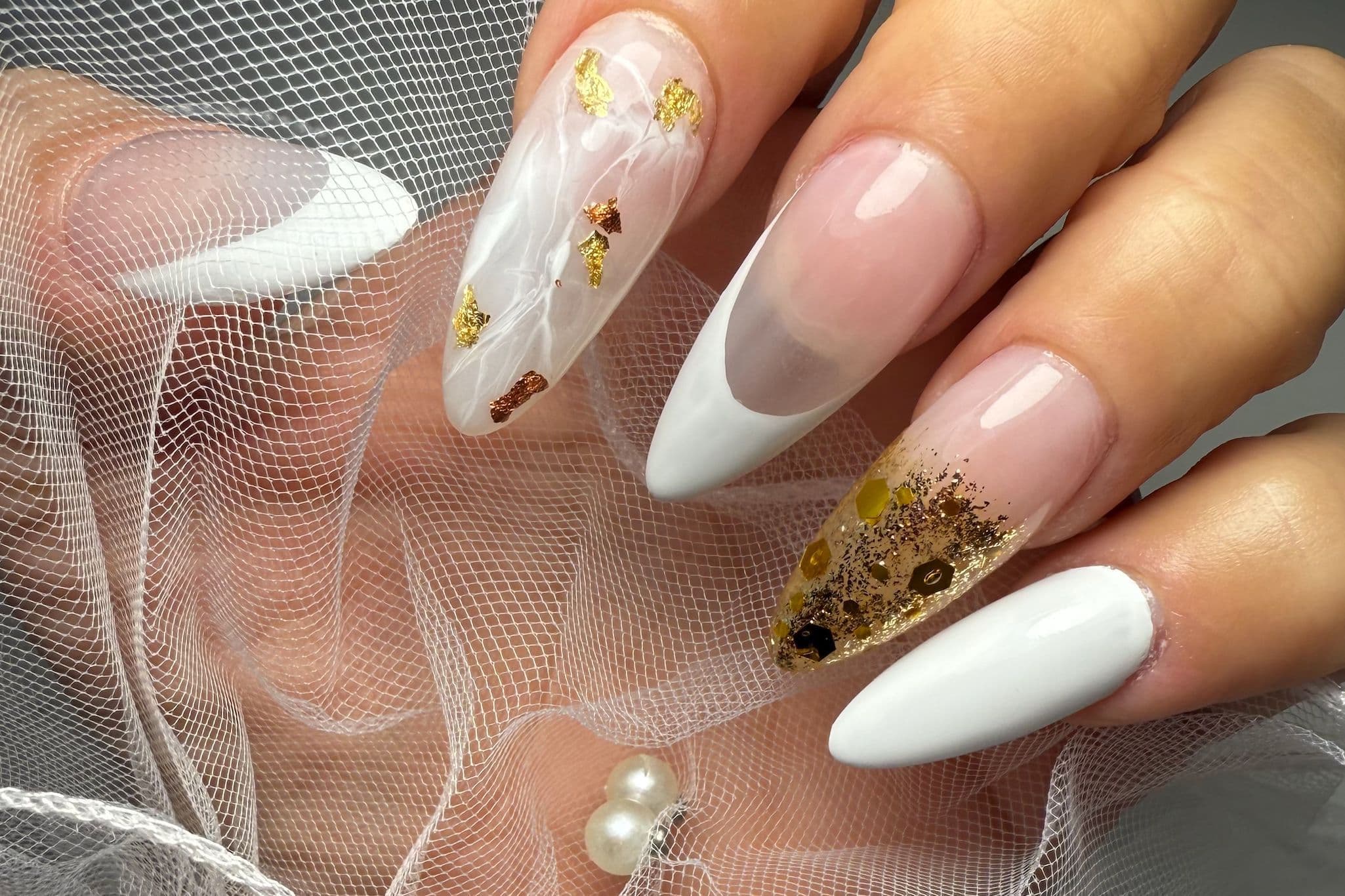 Almond nails with white marble art, French tips and gold details