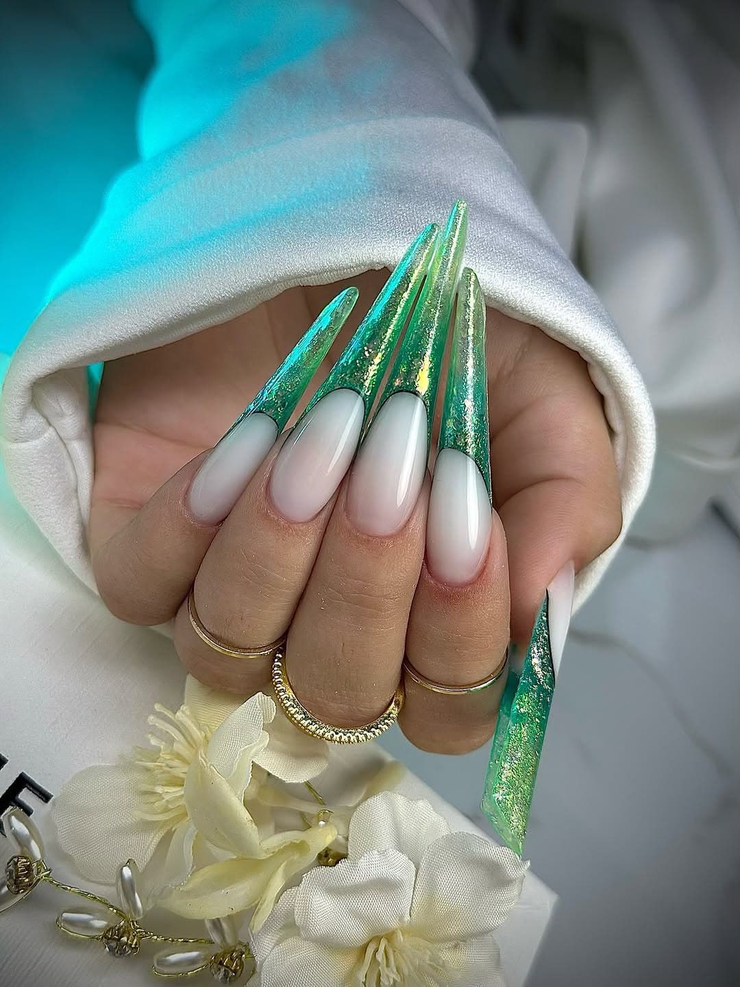 Extra-long green nails with gold foil and glitter tips